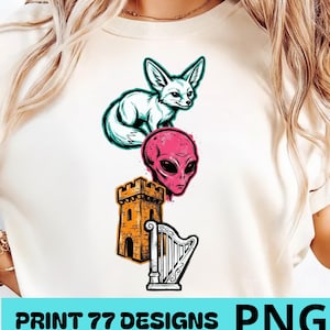 Op de afbeelding: Crèmekleurig T-shirt met een grafisch ontwerp van een witte vos, een roze alienhoofd, een oranje kasteel en een witte harp. De tekst "PRINT 77 DESIGNS PNG" staat onderaan.