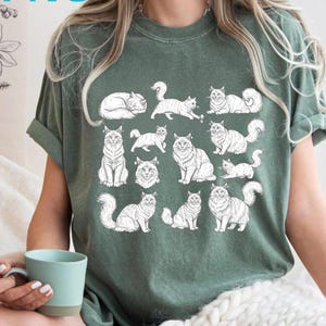 Peut inclure: T-shirt vert avec une illustration blanche de différentes races de chats. Le t-shirt porte les mots "DIGITAL PRODUCT" en bas et "PNG" en haut. Le t-shirt est de couleur verte unie.