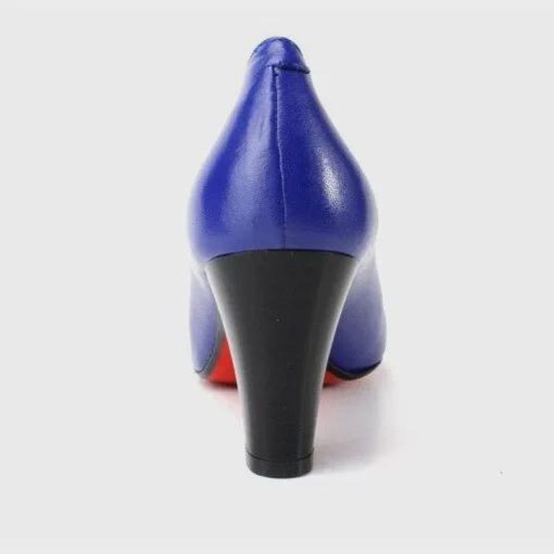 May include: A pair of blue high heels with a black heel and a red sole. The shoes are made of a smooth, shiny material and have a classic pump design. The heel is approximately 3 inches tall.