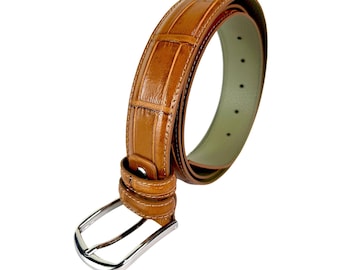 Può includere: Una cintura in pelle marrone con motivo a coccodrillo. La cintura ha una fibbia color argento e un interno verde chiaro. La cintura è larga circa 3,8 cm.