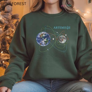 May include: A set of three ceramic mugs with a speckled, matte finish. The mugs are in shades of cream, light gray, and dark gray. Each mug has a simple, minimalist design, perfect for coffee or tea.