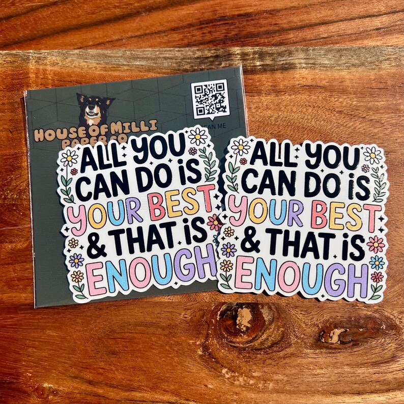 Puede incluir: Dos pegatinas con el texto "ALL YOU CAN DO IS YOUR BEST & THAT IS ENOUGH" en letras coloridas, rodeadas de dise&ntilde;os florales. Una tarjeta de visita con una ilustraci&oacute;n de perro y un c&oacute;digo QR est&aacute; detr&aacute;s de las pegatinas.