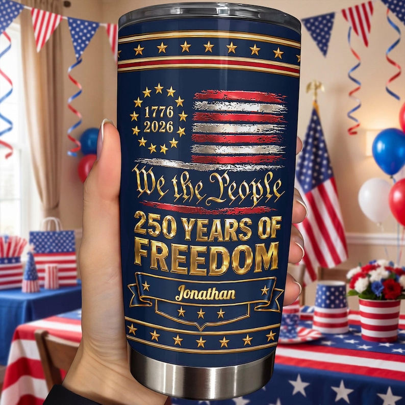 May include: A navy blue stainless steel tumbler featuring a distressed American flag, a circle of stars with the text 1776 2026, the phrase We the People, 250 YEARS OF FREEDOM, and a gold banner with the name Jonathan printed in a script font.