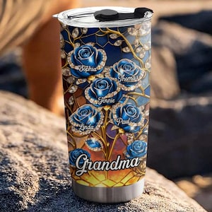 May include: A stainless steel tumbler with a blue rose design and the word "Grandma". The roses have the names Sophia, Thomas, Jennie, Linda, and Paul. The tumbler has a black lid.