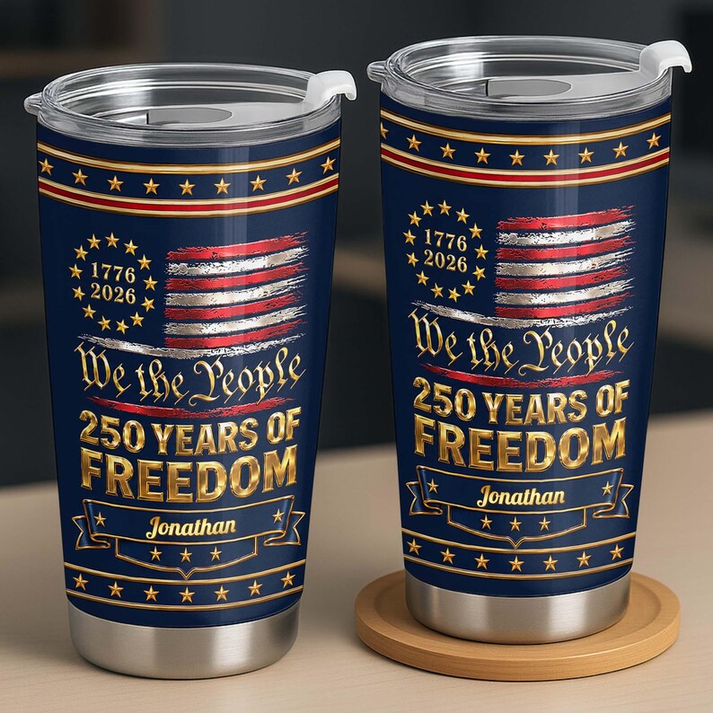May include: Two navy blue stainless steel tumblers with clear lids, featuring a distressed American flag, gold stars, and the text "We the People 250 YEARS OF FREEDOM" with the name "Jonathan" and the years "1776 2026" printed in gold lettering.