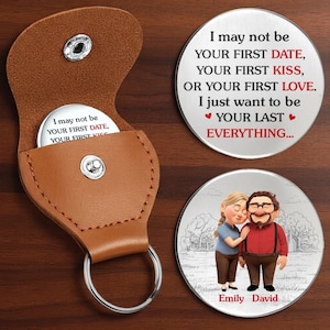 Può includere: Un portachiavi in pelle marrone con chiusura a bottone automatico argentato, contenente un gettone rotondo in metallo. Il gettone riporta la scritta "I may not be your first date, your first kiss..." Sono esposti due gettoni rotondi aggiuntivi, uno con testo e l'altro con un'illustrazione di coppia.
