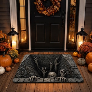 May include: A rectangular doormat featuring a 3D optical illusion of a deep, dark stone pit. The design depicts a human skull and several skeletal hands reaching upward from the depths of the brick-lined hole, creating a spooky, realistic effect.