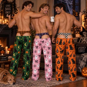 May include: Three pairs of Halloween-themed lounge pants featuring festive prints. One pair is green with black cats and pumpkins, one is pink with ghosts and spiderwebs, and one is orange with black cats, brooms, and potion bottles.