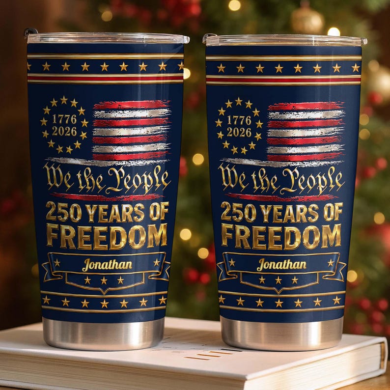 May include: Two navy blue stainless steel tumblers with a patriotic design featuring a distressed American flag, a circle of stars, and the text 1776-2026, We the People, 250 YEARS OF FREEDOM, and the name Jonathan printed in gold and white.