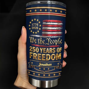 May include: A cylindrical stainless steel tumbler with a dark blue background featuring a distressed American flag, gold stars, and the text 1776 2026, We the People, 250 YEARS OF FREEDOM, and the name Jonathan printed in a gold banner at the bottom.