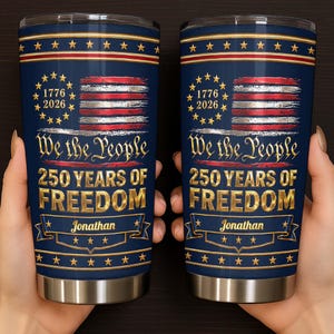 May include: Two cylindrical stainless steel tumblers with a dark blue background, featuring a distressed American flag, a circle of stars with the text 1776 2026, the phrase We the People, 250 YEARS OF FREEDOM, and the name Jonathan on a gold banner.