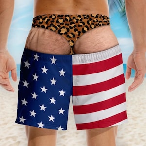 May include: Swim trunks featuring a split design with a blue field of white stars on the left and red and white horizontal stripes on the right. The waistband displays a brown and black leopard print pattern across the top section of the garment.