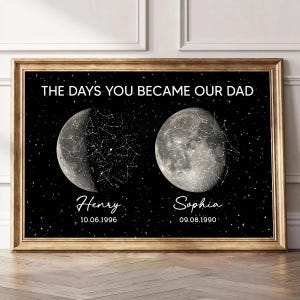 May include: A framed wall art print featuring a black background with white stars and two moon illustrations. The text reads THE DAYS YOU BECAME OUR DAD, Henry 10.06.1996, and Sophia 09.08.1990. Each moon is overlaid with white constellation line art.