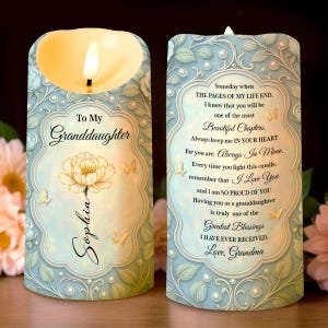 Op de afbeelding: Een lichtblauwe LED-kaars met een bloemenontwerp en de tekst "To My Granddaughter Sophia". De kaars heeft een warm, flikkerend licht en bevat een oprecht bericht van Grandma.