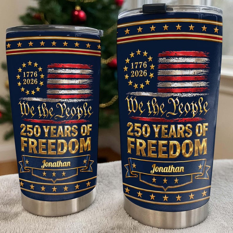 May include: Two navy blue stainless steel tumblers with lids, featuring a graphic of the American flag, the text 1776 2026, We the People, 250 YEARS OF FREEDOM, and the name Jonathan printed in gold lettering on a decorative banner design.
