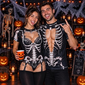 May include: Two black short-sleeved shirts featuring a white skeleton print. One shirt displays a skeleton ribcage with a lace-trimmed corset design, while the other features a skeleton ribcage with a bow tie and a heart-shaped cutout at the chest.