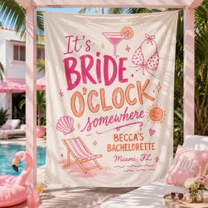 May include: A cream-colored fabric banner featuring pink and orange text that reads It's BRIDE O'CLOCK somewhere, BECCA'S BACHELORETTE, Miami, FL. Illustrations include a martini glass, a bikini top, a seashell, a sun, and a striped beach chair.