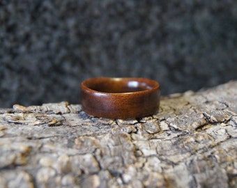 May include: A dark brown wooden ring with a smooth, polished finish.
