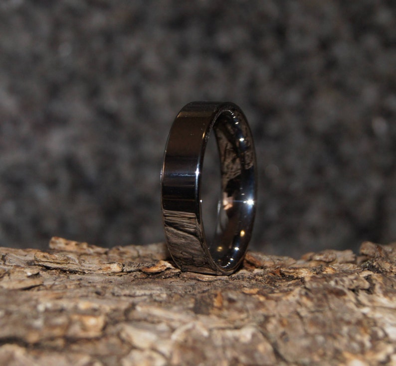 May include: A silver wedding band with a polished finish.