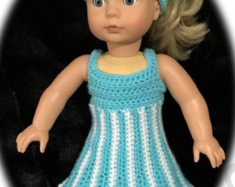 May include: A doll wearing a handmade crochet dress and headband. The dress is turquoise and white striped, with a matching turquoise headband adorned with a white flower. The doll also wears white shoes with ribbons.