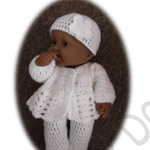 Puede incluir: Conjunto de bebé de ganchillo blanco con un gorro a juego. El conjunto incluye un cárdigan, pantalones y un gorro con un detalle de flor.