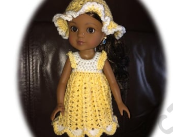 May include: A doll wearing a yellow crocheted dress with white trim and a matching yellow crocheted sun hat with white trim.
