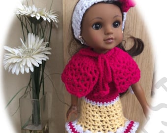 May include: A doll wearing a pink crocheted cape, a yellow and white crocheted skirt with a pink trim, and a white crocheted headband with a pink bow.