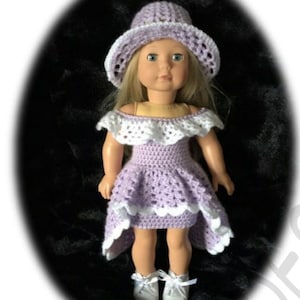 May include: A crocheted doll dress and hat set in lavender and white. The dress has a high-low hemline and a ruffled neckline. The hat is a wide-brimmed sun hat.