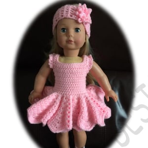 Può includere: Un vestito rosa all'uncinetto con una gonna a balze e una fascia per capelli in crochet rosa abbinata con un accento floreale. L'abito è progettato per una bambola.