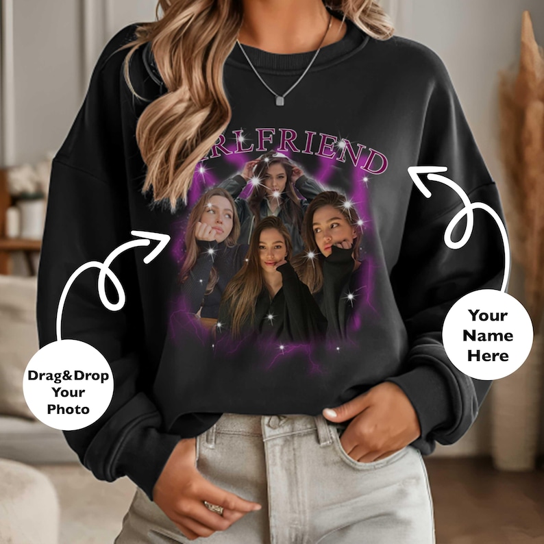 May include: Black sweatshirt featuring a graphic of four women with the word "GIRLFRIEND" in pink above them. The design is surrounded by a purple aura with lightning bolt accents. The sweatshirt has a crew neck.