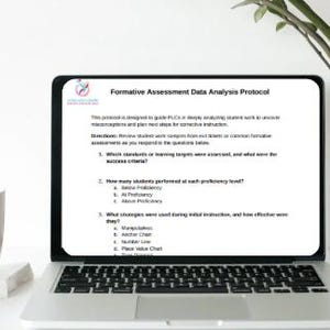 May include: A laptop screen shows a document titled "Formative Assessment Data Analysis Protocol." The text includes bullet points and questions. A white mug and a potted plant are on the table.