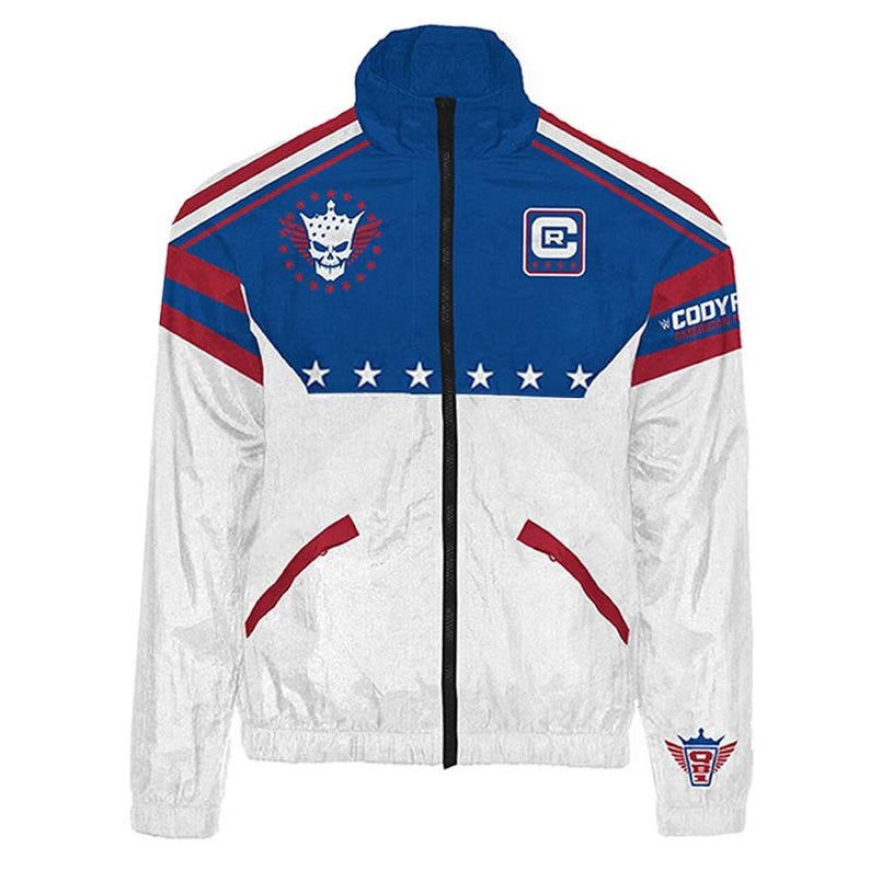 May include: White and blue zip-up jacket with red accents. Features a skull and crown emblem, stars, and the text "Cody R". The jacket has a high collar and a full-length black zipper. A logo is on the lower right.