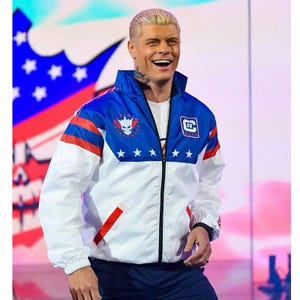 May include: A white, blue, and red zip-up jacket with a star and skull logo. The jacket has a blue collar and shoulders, white body, and red accents. The jacket has a small patch with a letter "E" on the right side.