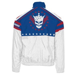 May include: White and blue track jacket with a skull and crown graphic on the back. The jacket has red accents and the word "RHODES" on the shoulder. Features a full zip and a stand-up collar.