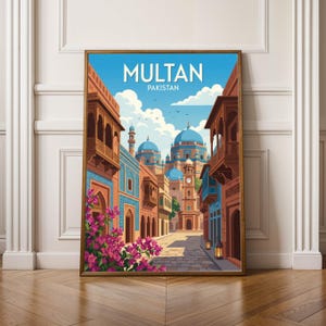 May include: A framed art print featuring a vibrant illustration of Multan, Pakistan. The artwork depicts a street scene with colorful buildings, blue domes, and the text "MULTAN PAKISTAN" at the top. Pink flowers and a clear blue sky complete the scene.