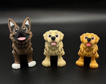 May include: Three dog figurines in a row. The first is a German Shepherd with brown and black fur, the second is a light tan dog, and the third is a golden retriever. All have pink tongues and black eyes.