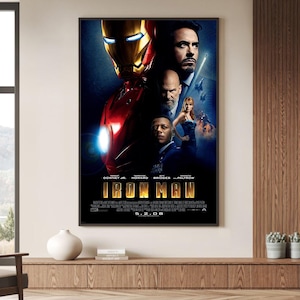 Könnte beinhalten: Ein rechteckiges Filmplakat für Iron Man mit einem großen rot-goldenen Rüstungsanzug, einem Mann im Anzug, einem glatzköpfigen Mann mit Bart und einer Frau im blauen Kleid. Der Titel IRON MAN steht in großen goldenen Buchstaben mit 5.2.08.