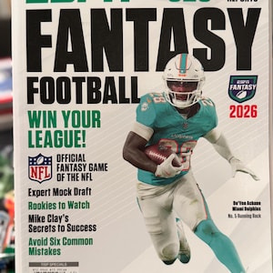 May include: The ESPN Fantasy Football 2026 magazine cover features a Miami Dolphins player in a teal uniform holding a football. Text includes 325+ Player Scouting Reports, Win Your League, Official Fantasy Game of the NFL, and De'Von Achane.