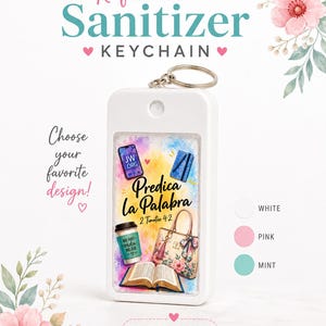 May include: A white refillable sanitizer keychain with a design featuring the text "Predica La Palabra" and other graphics. The keychain has a silver ring and is available in white, pink, and mint colors. The text "Choose your favorite design!" is also visible.