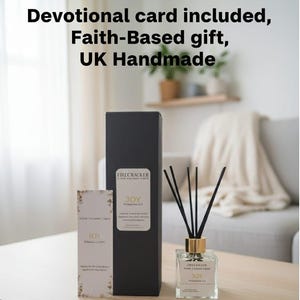 May include: A reed diffuser with a gold collar and black reeds, a black box, and a small card are displayed on a wooden table. The text on the box and bottle reads "JOY" and "FIRECRACKER". The card has gold floral accents.