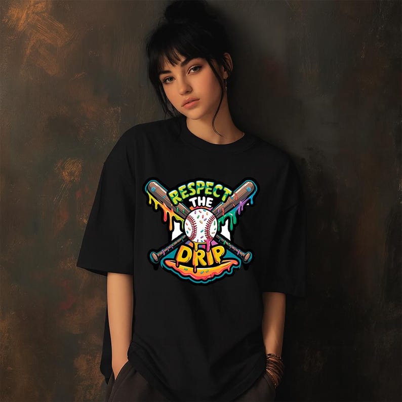May include: Black t-shirt featuring a baseball-themed graphic. The design includes crossed baseball bats, a baseball, and the text "Respect the Drip" in a colorful, dripping font. The shirt is a casual, short-sleeved style.