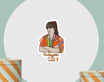 Peut inclure: Autocollant avec une illustration de dessin animé d'une personne en tenue colorée, les bras croisés. Le texte "Halloween is Cool?" est écrit à la main. Le fond est de couleur vert d'eau.