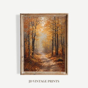 Op de afbeelding: Een olieverfschilderij van een herfstbos. Het kunstwerk toont een pad dat door bomen met gouden bladeren slingert. Het schilderij is ingelijst in een houten lijst in vintage stijl. De tekst "JD VINTAGE PRINTS" staat onderaan de afbeelding.