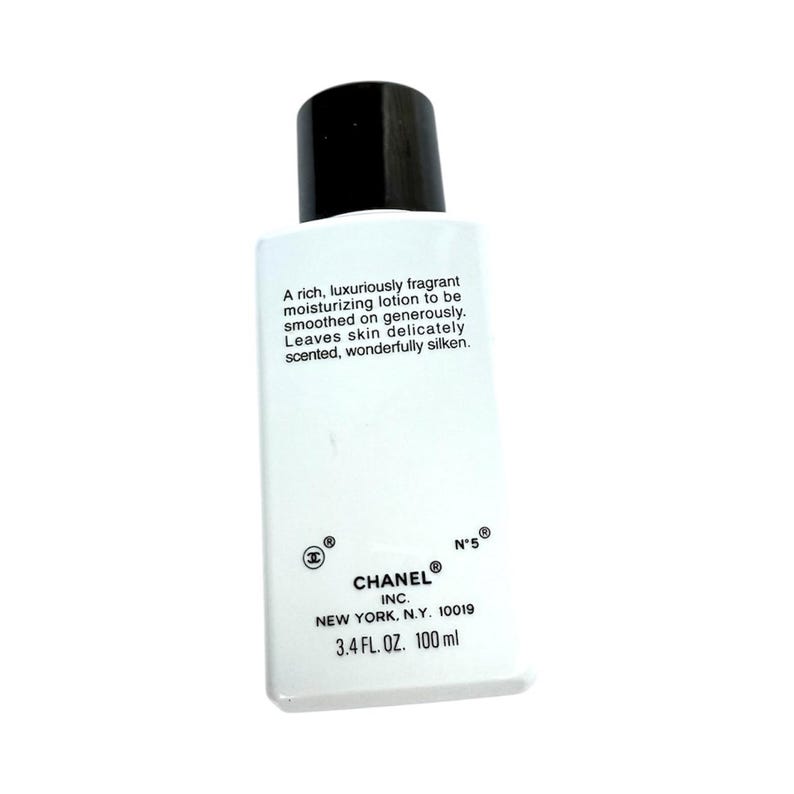 May include: White rectangular bottle of Chanel N&deg;5 moisturizing lotion with a black cap. The bottle has text that reads, "A rich, luxuriously fragrant moisturizing lotion..." and "3.4 FL. OZ. 100 ml."