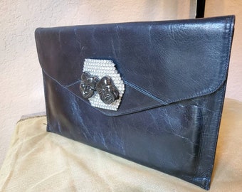 Black leather clutch envelope style with a clear rhinestone deco and ceramic drama faces designed by Amanda Alarcon-Hunter for Minx and Onyx