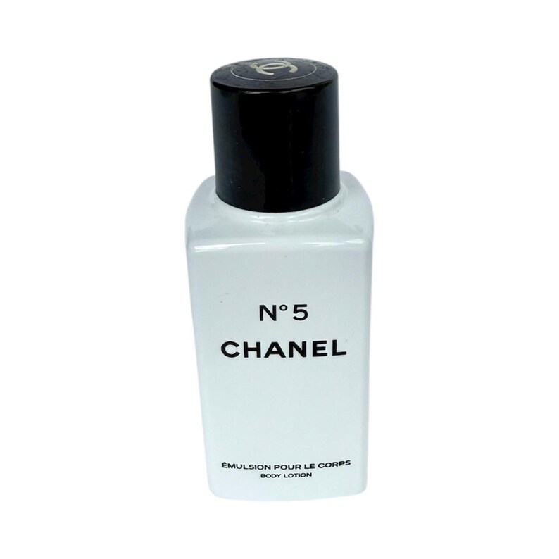 May include: A small, rectangular bottle of Chanel No. 5 body lotion. The bottle is clear with a black cap and features the brand name and product details in black lettering. The lotion is labeled "&Eacute;mulsion pour le corps / Body Lotion."
