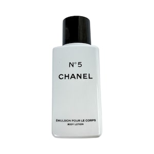 May include: A white rectangular bottle of Chanel N&deg;5 body lotion with a black cap. The product name and brand are printed in black. The bottom of the bottle reads "&Eacute;MULSION POUR LE CORPS BODY LOTION."