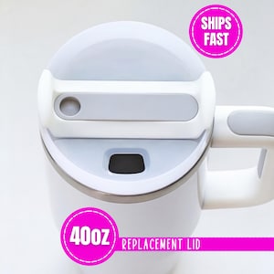 May include: A white 40oz replacement lid for a tumbler, featuring a light gray sliding closure mechanism and a matching gray handle grip. The lid has a circular opening and a rectangular sliding tab, designed to fit securely onto a beverage container.