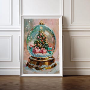 May include: A framed painting depicting a snow globe with a Christmas tree inside. The tree is adorned with decorations and lights, and surrounded by wrapped presents. The snow globe rests on a decorative base, within a white frame.