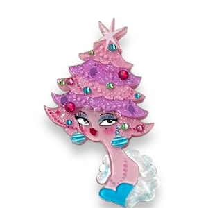 Peut inclure: Broche fantaisiste en forme de sapin de Noël rose et violet, avec un visage et des boucles d'oreilles pendantes. La broche est ornée de pierres précieuses colorées et d'une étoile sur le dessus, créant un accessoire festif et unique.